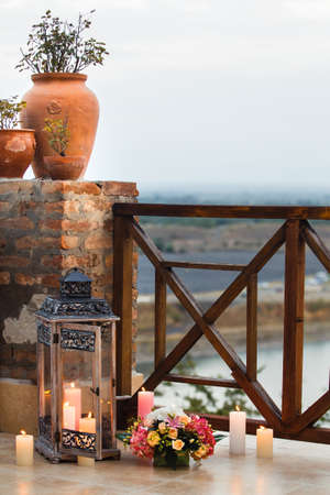 Flowers and vases with plants. Lantern and burning candlesの写真素材