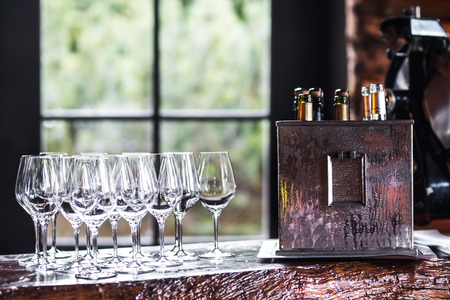Empty wineglasses on table in restorane and box with alcohol.