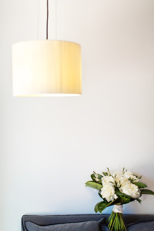Beautiful wedding bouquet on a sofa. Beige lamp.の写真素材