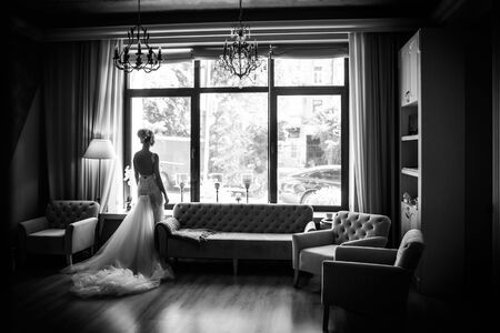 Beautiful bride stands near the window. Wedding dayの写真素材