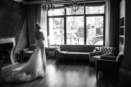Beautiful bride stands near the window. Wedding dayの写真素材