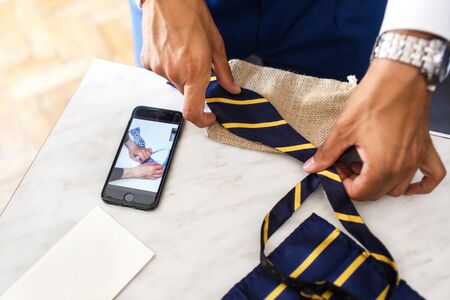 The groom knit a bow tie. Wedding preparation.の写真素材