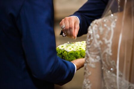 Bride gives an engagement ring to her Groom. Wedding and honeymoon concept. wedding day. focus on hand and ring.の写真素材