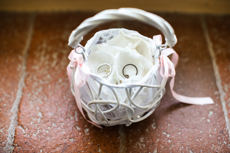 White basket with wedding rings on the table.の写真素材
