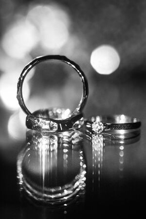 Three wedding rings on the reflecting surface with highlights.の写真素材