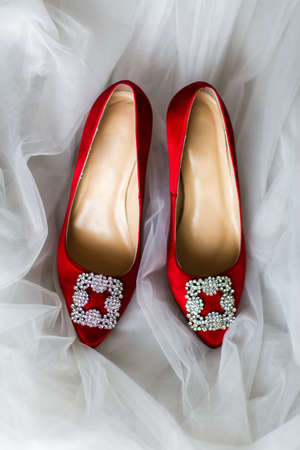 Red wedding shoes with jewels on a white backgroundの写真素材