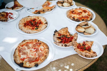 Pizzas on the table in plastic plates.の写真素材