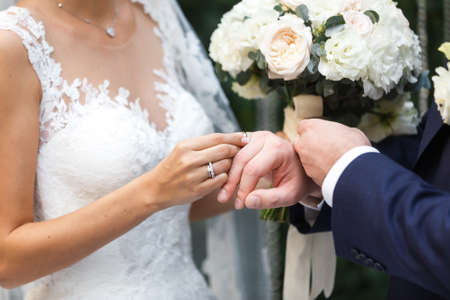 The bride wears a ring to the groom at the wedding ceremonyの写真素材