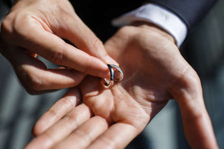 Two wedding rings in the hands of the groom.