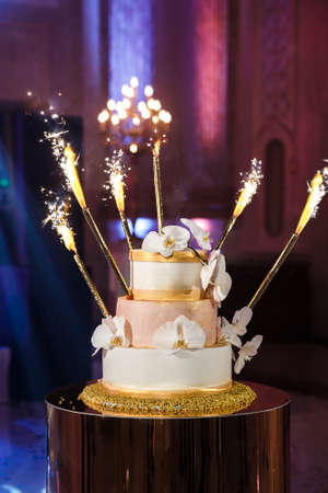 Multilevel wedding cake decorated with colorful flowers.