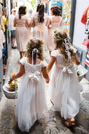 Little bridesmaids stand in front of the entrance to the church.の写真素材