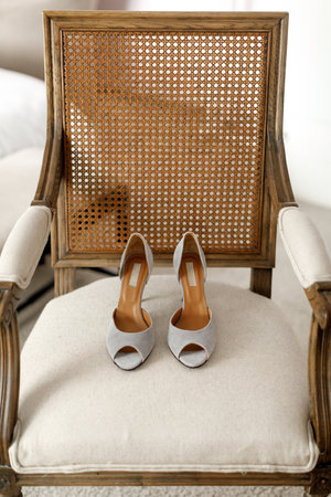 Silver wedding shoes on a beige chair.の写真素材