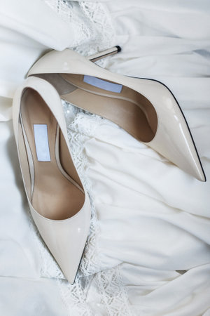 White shoes lie on a wedding dress.の写真素材