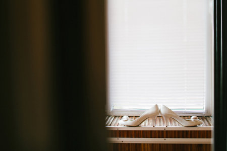 Beige wedding shoes stand on the window.の写真素材