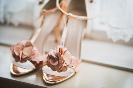 Pink wedding shoes on a wooden windowsill.の写真素材
