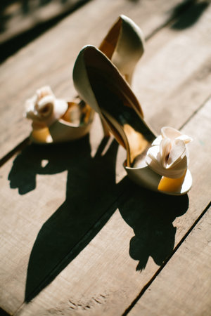 Beige wedding shoes on a wooden windowsill.の写真素材