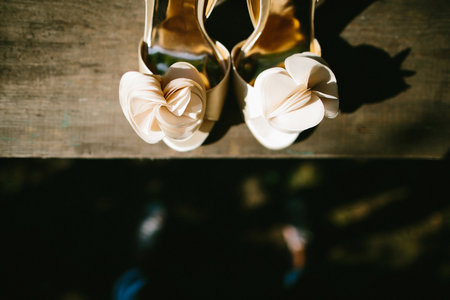 Beige wedding shoes on a wooden windowsill.の写真素材