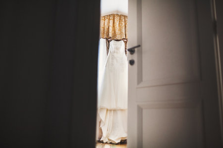 Wedding dress hanging in the room near the window.の写真素材