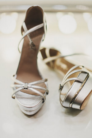 Silver wedding shoes on a beige table.の写真素材