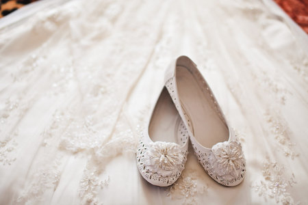 White shoes lie on a wedding dress.の写真素材