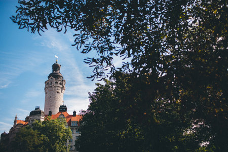 High tower near the houses with a view through the foliage.