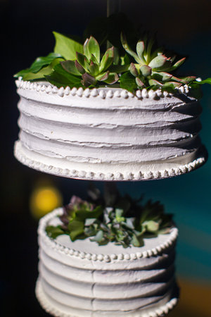 Multilevel wedding hanging cake decorated with flowers. Closeup