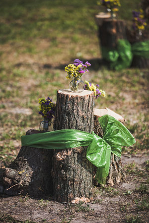 Beautiful and delicate flowers at the wedding ceremony. Flowers in vases on wooden stumpsの写真素材