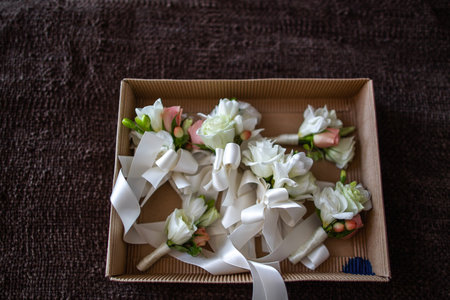 Set of wedding boutonnieres in a cardboard box.