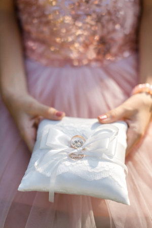 Bridesmaid with wedding rings on the pillow.の写真素材