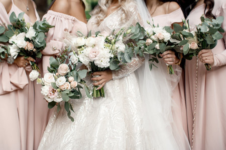 Bride with bridesmaids with flowers stand in a row.の写真素材