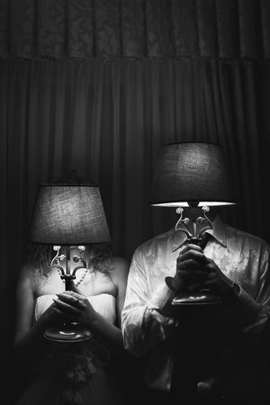 Bride and groom on their wedding day. Newlyweds hold floor lamps in their handsの写真素材