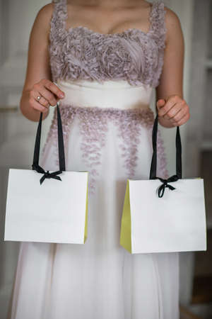 Bride in the morning during wedding preparations. Bride holding gift bagsの写真素材