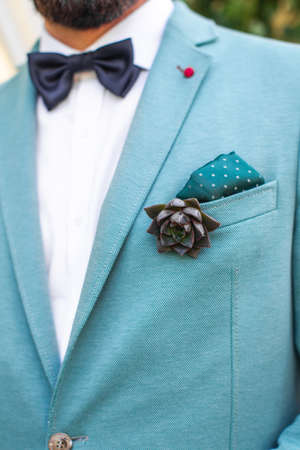 Elegant wedding boutonniere on the groom's suit.