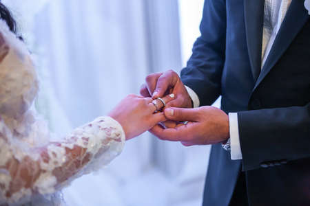 Bride and groom exchange rings at the wedding ceremony.