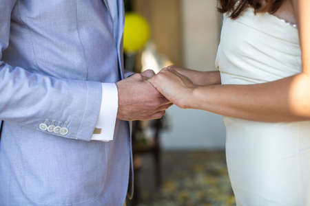The bride and groom hold each other's hands.の写真素材