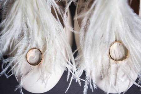Two golden rings lie on wedding shoes.の写真素材