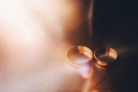 Two wedding rings on a shiny background.の写真素材