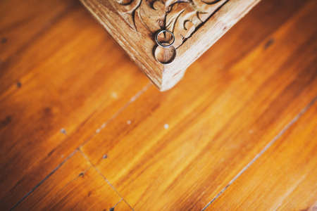 Two wedding rings on the corner of a wooden vintage table.の写真素材