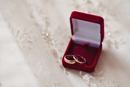 Two wedding rings in a red box on a dress.の写真素材