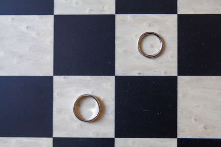 Two wedding rings lie on a chessboard,の写真素材