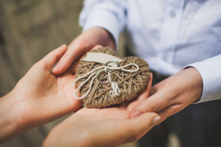 Three wedding rings on a heart made of ropes.の写真素材