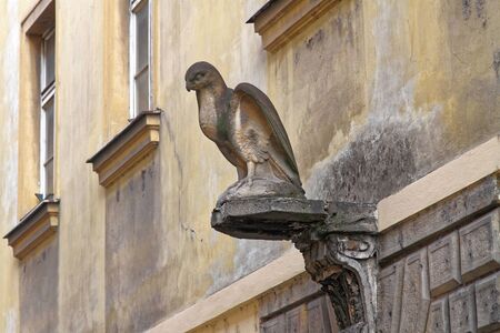 A stone eagle sculpture on a wall of an old houseの写真素材