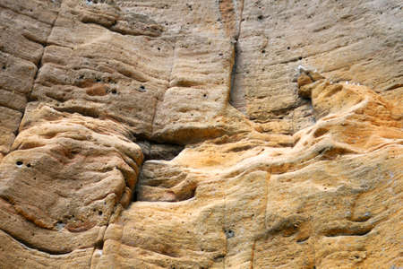 Photo of weathered eroded yellow rock surface