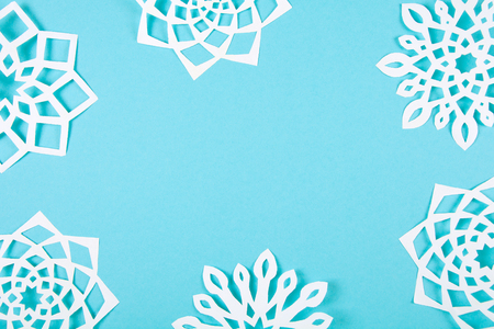 Paper snowflakes on blue background. Top view. Christmas decoration. Tonedの写真素材