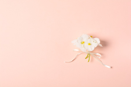 Bouquet of violet flowers (viola) and empty greeting card on pink paper background. Valentine's day celebration concept. Top view. Flat lay. Mock-upの写真素材