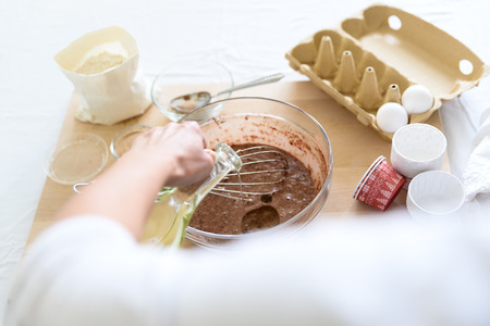 Cooking Christmas chocolate muffins. Mixing ingredients for brownies, cupcakes, pancakes. Woman hands preparingの写真素材
