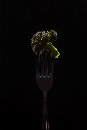 Broccoli on fork isolated on black backgroundの写真素材