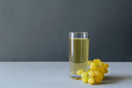 White grape juice with grapes on gray wooden background. Healthy eating concept. Coopy space.の写真素材