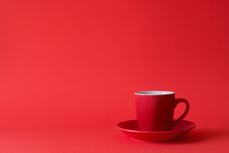 Red cups of tea or coffee on red paper background. Copy spaceの写真素材