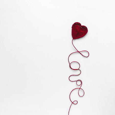 Creative concept. Kate and Love word from red knitting yarn on white wooden background. Flat lay....